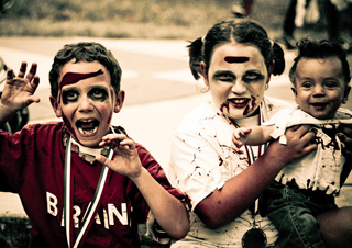 Three kids dressed in zombie costumes posing for the camera. Three kids dressed in zombie costumes posing for the camera.